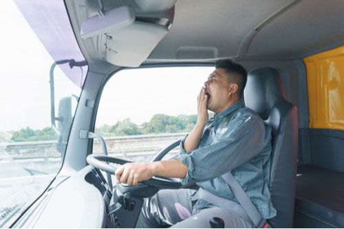 Truck driver yawning while driving