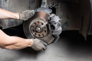 mechanic changing brakes on a car